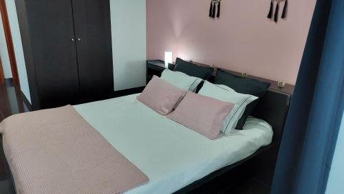 Lajes das FloresRetiro das Camélias的一间卧室配有一张带两个粉红色枕头的床