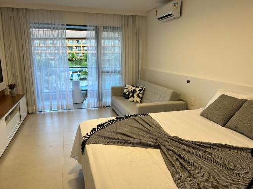 塔曼达雷Flat com vista linda Eco Resort的一间卧室配有一张床,客厅配有沙发