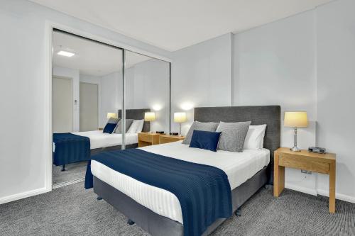 悉尼North Sydney Large Two Bedroom MIL2302的酒店客房,设有两张床和镜子