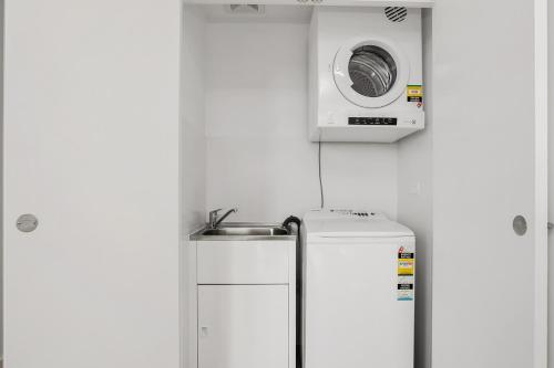 悉尼North Sydney Large Two Bedroom MIL2302的冰箱上方的微波炉,带水槽
