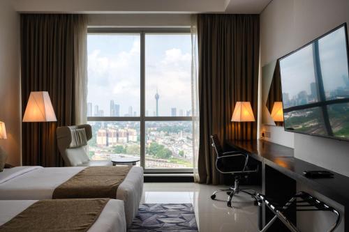 科伦坡Orion City Hotel的酒店客房设有两张床、一张桌子和大窗户。