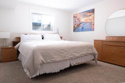 萨里Modern yet comfy 3 bed suite in Surrey的一间卧室配有一张带镜子和梳妆台的床