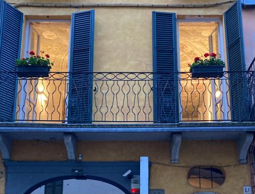 布雷西亚Casa Roveglia的阳台设有蓝色百叶窗和鲜花