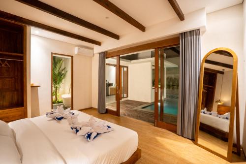 乌鲁瓦图Atania Villa's Bingin的一间带大床的卧室和一个游泳池