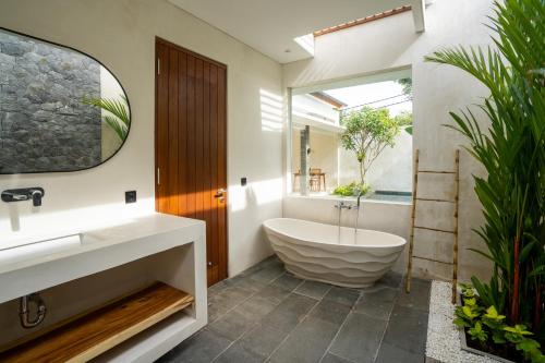 乌鲁瓦图Atania Villa's Bingin的带浴缸、水槽和镜子的浴室