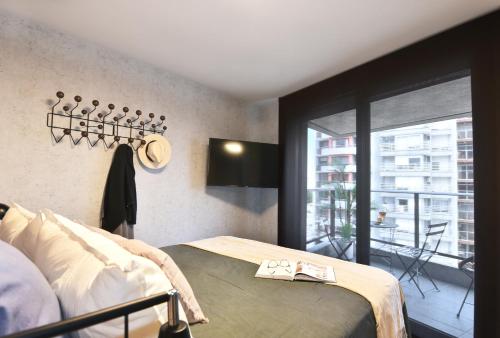 蒙得维的亚Moderno apartamento en Punta Carretas的一间卧室设有一张床和一个阳台