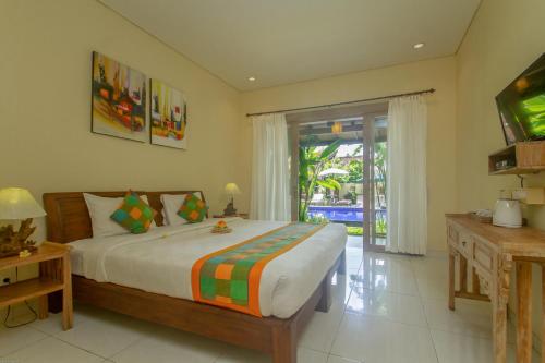 乌布KUDESA Homestay by Pramana Villas的一间卧室设有一张大床和一个滑动玻璃门