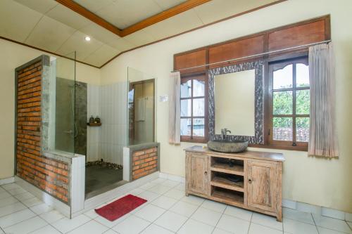 乌布KUDESA Homestay by Pramana Villas的带淋浴、盥洗盆和镜子的浴室
