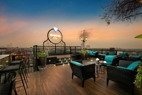 河内La Mejor Hotel & Sky Bar的一个带桌椅的屋顶露台和一个读书sharmaarma的标志