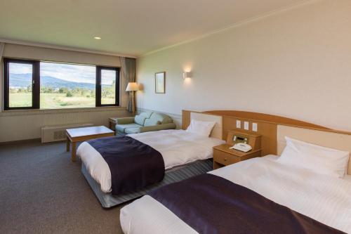 中富良野町富良野拉渔村酒店的酒店客房设有两张床和窗户。