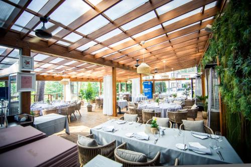 巴蒂泽巴特薇拉酒店的餐厅设有白色的桌椅和天花板