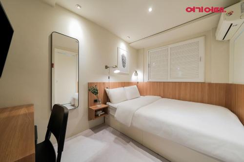 首尔Hotel Less Seoul的卧室配有一张白色大床和镜子