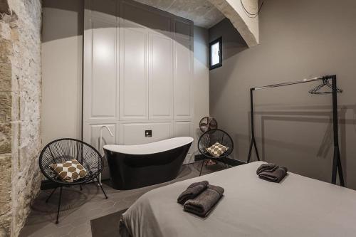 拉巴特Rabat l.o. MDINA-Designer House THE BEDROOM-TUB的卧室配有1张床、浴缸和椅子