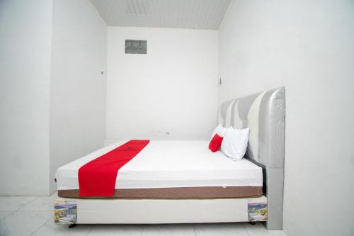 TakengonRedDoorz Syariah near Danau Lut Tawar Takengon 2的白色卧室配有一张带红色毯子的床