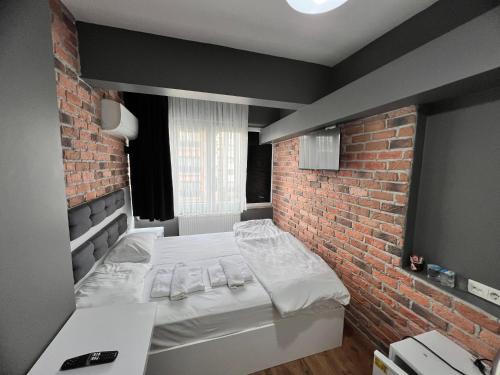 图兹拉Karaca Suite的砖墙房间的一个床位