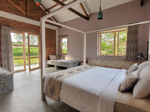 特特巴图Les Rizieres Lombok - Tetebatu的一间设有床铺的卧室,位于带窗户的房间内