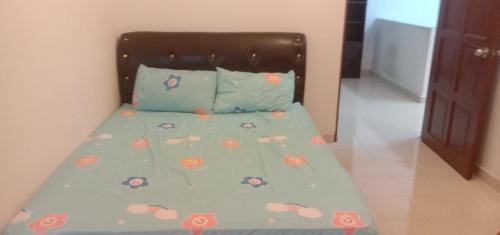 马兰Homestay Humair的一张带蓝色棉被的床,上面有螃蟹