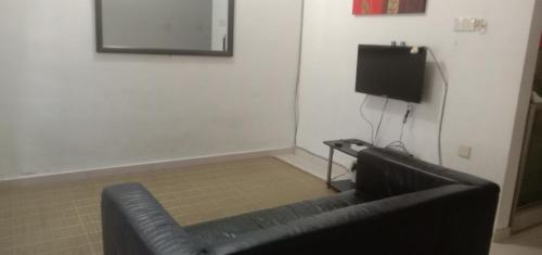马兰Homestay Humair的电视室里的一张黑色皮沙发