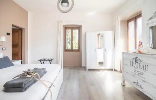 克雷米亚B&B La Dolce Casa Lago di Como的一间白色的大卧室,配有一张床和一个梳妆台