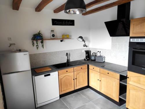 LigueilMaison de charme的厨房配有木制橱柜和白色冰箱。