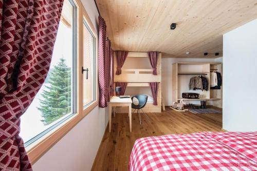 上施陶芬Gähwindehof Mountain Ranch Resort的一间卧室设有一张床和一个大窗户