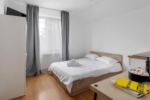 克卢日-纳波卡DD Boutique Apartments的一间卧室配有一张床、一张书桌和一个窗户。