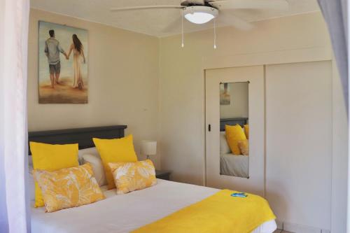 乌旺戈海滩Laguna la Crete 66的一间卧室配有一张带黄色枕头的床