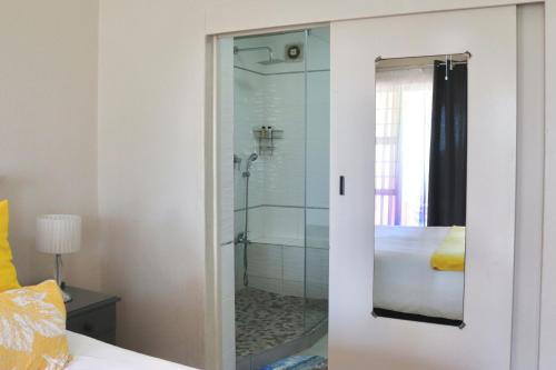 乌旺戈海滩Laguna la Crete 66的带淋浴的浴室和玻璃门