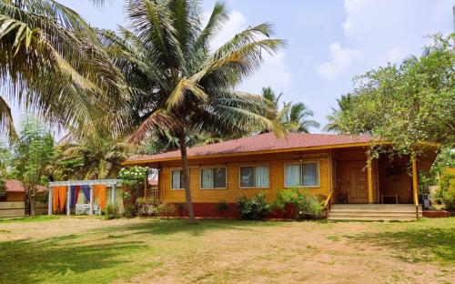 班加罗尔Brahmi Resort的前面有棕榈树的房子