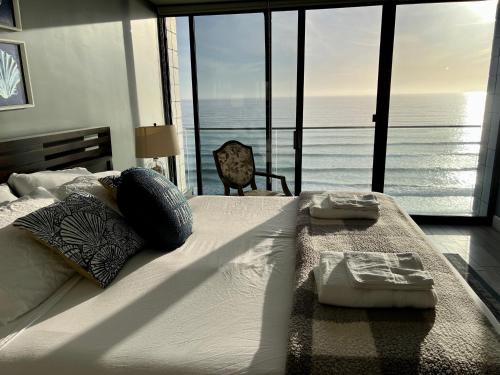 圣地亚哥Ocean View Luxury Condo Oceanfront and Pool的一间卧室设有一张床,享有海景