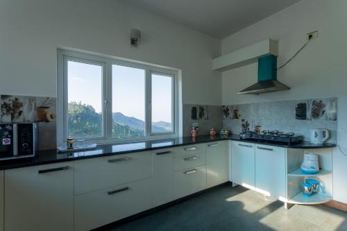 乌提lynfields leisure的一间厨房,配有白色的橱柜和大窗户