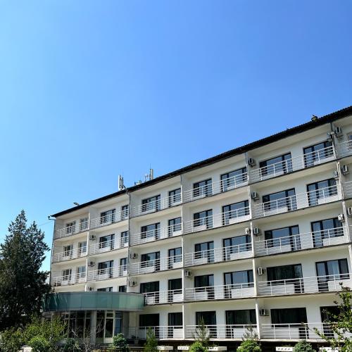 奇姆肯特TOURIST HOTEL的公寓大楼的背景是蓝色的天空