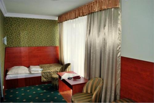 波拉齐克Przystań Caryńska w Polańczyku的酒店客房带一张床、一张桌子和椅子