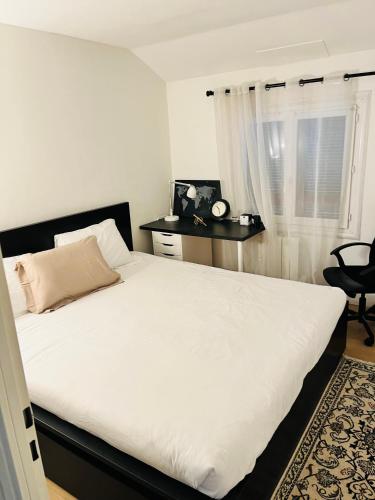 鲁瓦西昂法兰西Private rooms in a Tiny home 4 min drive to Airport CDG ,1 private bathroom ideal for families and friends的卧室配有白色床、椅子和窗户