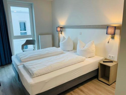 卡珀尔恩Fewo Frida BOW 321的卧室配有一张带白色床单和枕头的大床。