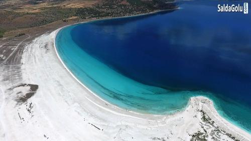 YeşilovaSalda Gölüne çok yakın的享有蓝色海水海滩的空中景致