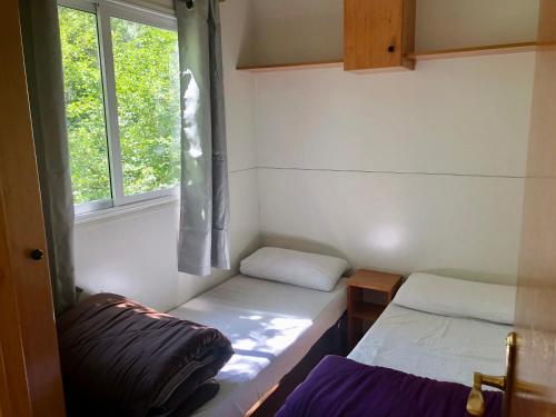 利亚沃尔西Camping Aigües Braves的小房间设有两张床和窗户