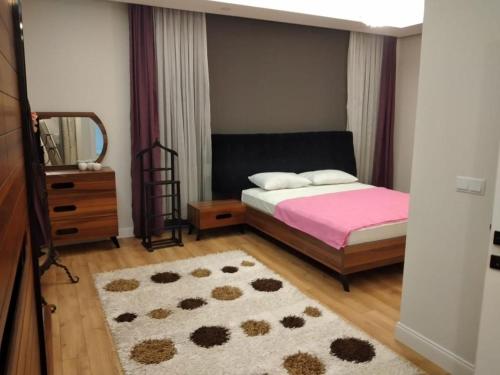 安塔利亚Sakın bir ortamda 3 odalı villa的一间卧室配有床、镜子和地毯