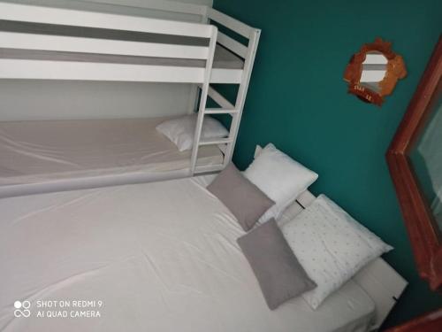 贝斯和圣阿纳斯泰斯Chez Loïc et Mélanie的一间小卧室,配有白色双层床和枕头
