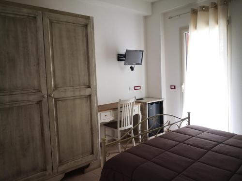 维科德尔加尔加诺Da Alduccio的一间卧室配有一张床、一张书桌和一台电视。