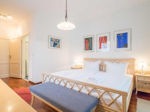 萨斯尼茨Appartementhaus Sonnenbad - Luxuspenthouse App. 11的一间卧室配有一张白色大床和蓝色长凳