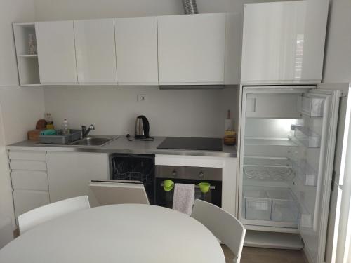 塞扎纳Apartments B&M的厨房配有白色橱柜和白色冰箱。
