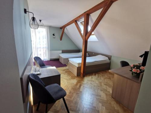 波兹南叶丽涅茨酒店的小房间设有一张床、一张桌子和椅子