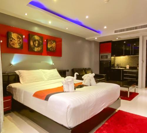芭东海滩绝对班各拉套房酒店的一间带白色大床的卧室和一间厨房