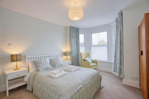 埃克斯茅斯5 Bedroom Family Retreat Exmouth, Devon的卧室配有床、椅子和窗户。