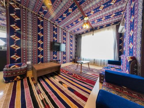 亚历山大Downtown Sea View Suites的客厅拥有色彩缤纷的墙壁、电视和地毯。
