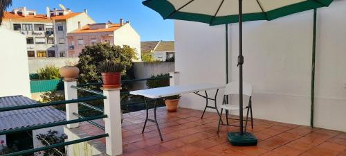 新皮尼亚尔Casa da Forja的阳台配有桌椅和遮阳伞