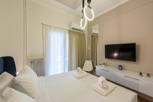 雅典MEDLUXE COZY APARTMENT!的白色卧室配有一张大床和两条毛巾