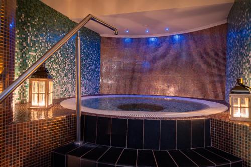 德兹维济诺哈维特Spa度假酒店的带有马赛克瓷砖的房间的按摩浴缸