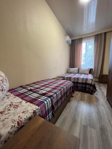 茨卡尔图博Guest House Kolkha的酒店客房设有两张床和窗户。